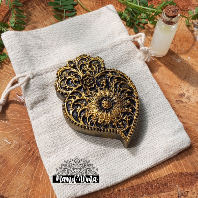 Selo de cera dourado com desenho floral sobre saco de algodão cru e pequena garrafa de vidro com rolha