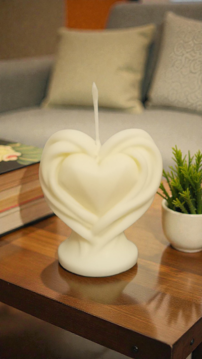 Vela branca em forma de coração numa mesa de madeira