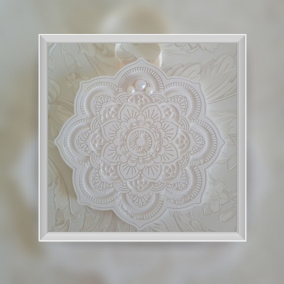 Mandala decorativa branca com relevo detalhado em fundo texturizado floral claro