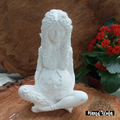 Estátua branca de mulher sentada com detalhes em fundo de madeira e planta com flores vermelhas