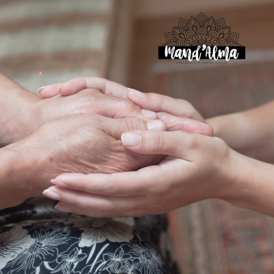 Duas mãos entrelaçadas, uma mais velha e outra mais jovem, sobre fundo desfocado com tecido floral