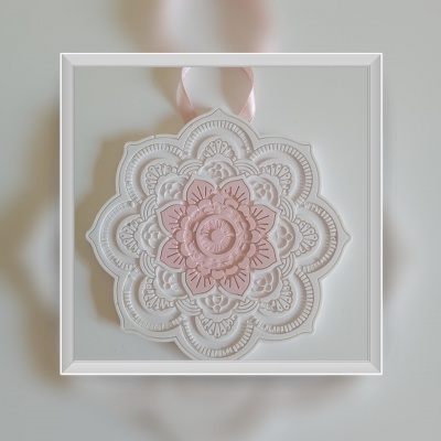 Medalhão cerâmico decorativo branco e rosa com padrão floral e fita para pendurar