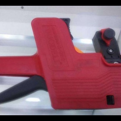 Arma de etiquetagem manual vermelha com gatilho preto e botão vermelho