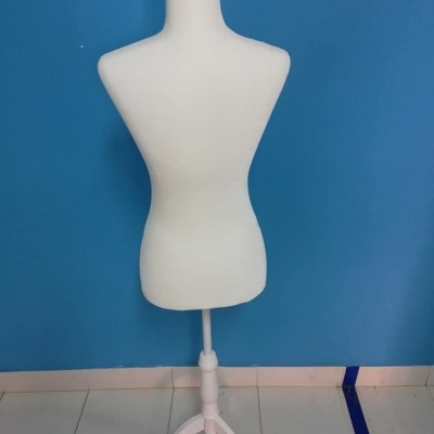 Manequim de alfaiate branco contra parede azul