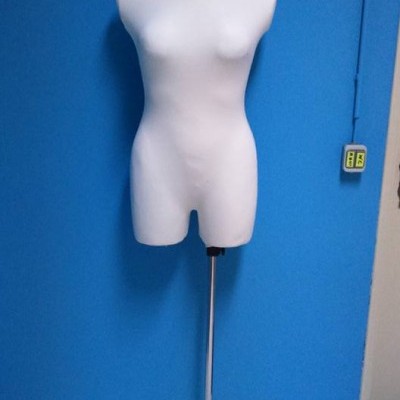 Manequim feminino branco com estrutura metálica em fundo azul