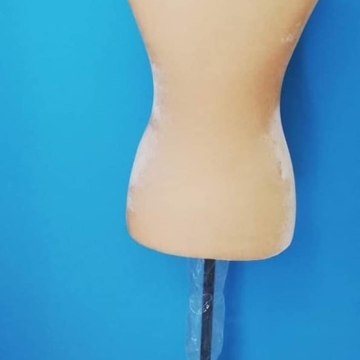 Manequim de costura feminino com suporte preto e envolto em plástico