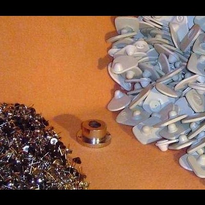 Tachinhas e fitas adesivas com alfinetes sobre fundo castanho