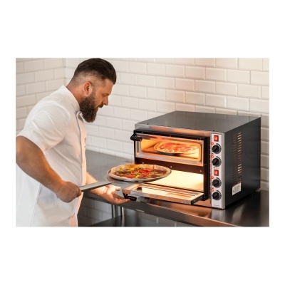 Homem a colocar pizza em forno elétrico preto de bancada em cozinha com azulejos brancos