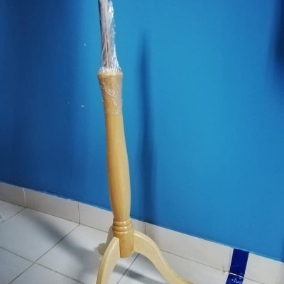 Base de madeira clara com pernas curvas e parte coberta em plástico numa parede azul