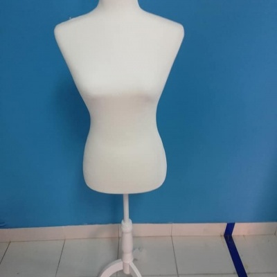 Manequim de alfaiate branco com suporte e base branca em fundo azul.