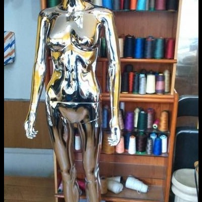 maniquim cromado feminino em estante de linhas coloridas