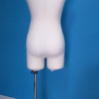 Manequim de torso feminino branco com base metálica em sala com parede azul