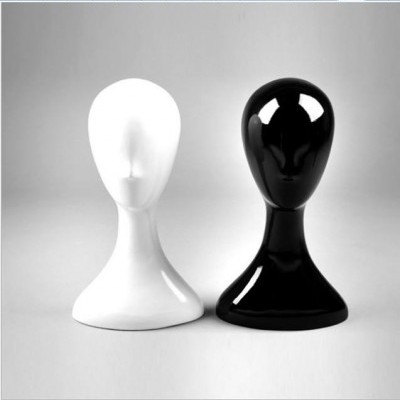 Dois manequins de cabeça, um branco e outro preto, com acabamento brilhante