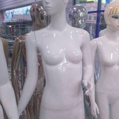 Mannequins femininos brilhantes de cores branca, dourada e cromada em loja