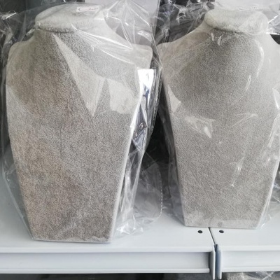 Expositores de colares em veludo cinzento claro embalados em plástico em prateleira