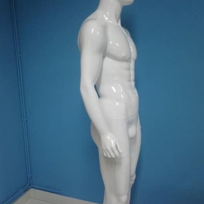 Mannequim masculino branco em perfil contra parede azul