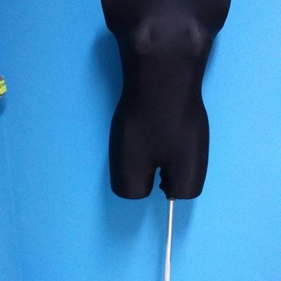 Manequim feminino preto com suporte metálico num fundo azul