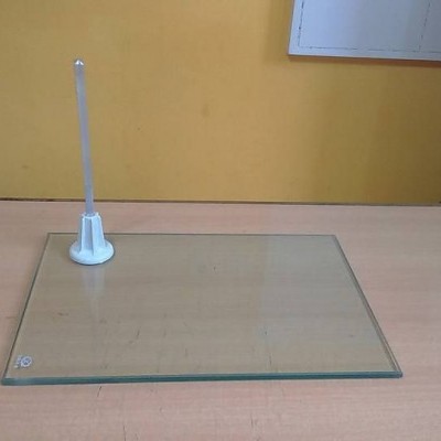 Suporte de vidro transparente com haste branca em superfície de madeira