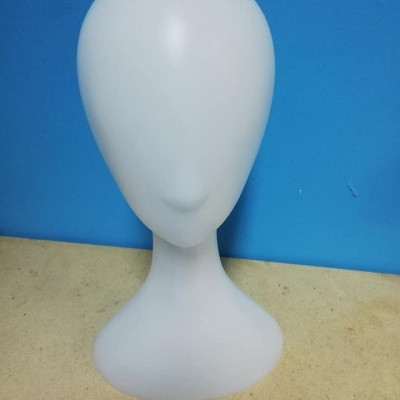 Manequim branco para exibição de acessórios em superfície bege e fundo azul