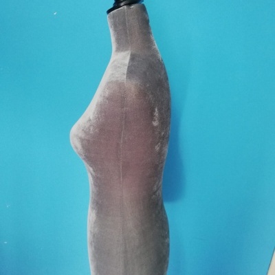 Manequim de costura feminino cinza contra parede azul