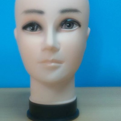 Cabeça de manequim em plástico com olhos pintados e sobrancelhas escuras