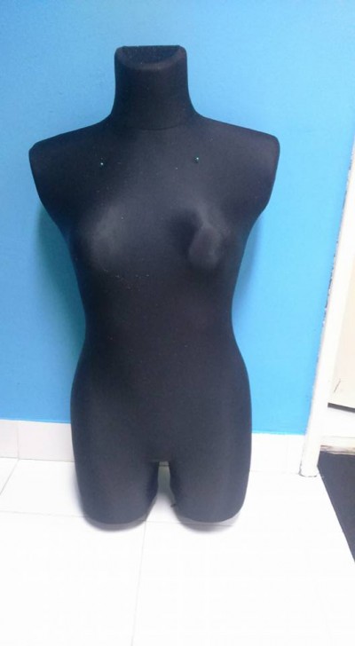 Manequim feminino preto contra parede azul