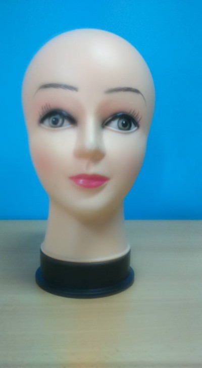 Cabeça de manequim feminina com maquilhagem e base preta sobre mesa