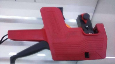 Arma de etiquetagem manual vermelha com gatilho preto e botão vermelho