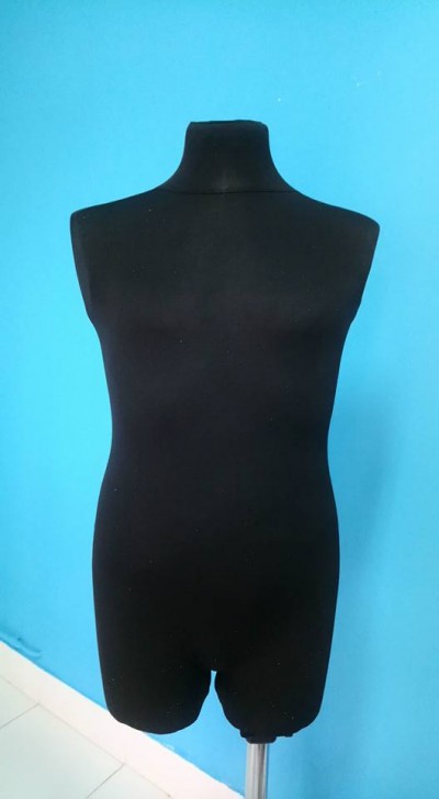 Manequim masculino meio corpo em tecido preto contra parede azul