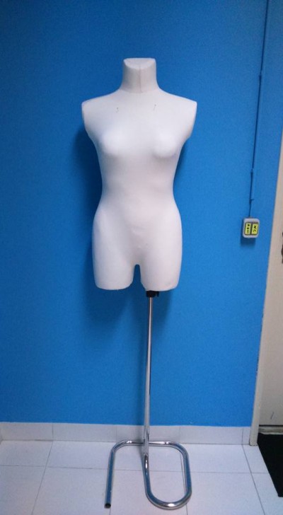 Manequim feminino branco com estrutura metálica em fundo azul