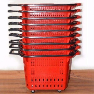 Cestos de compras vermelhos empilhados com rodas e puxadores pretos