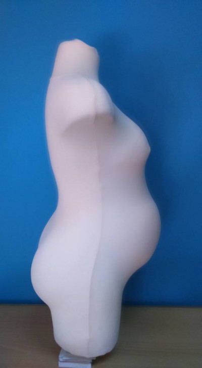 Torso de manequim branco sem cabeça nem braços em fundo azul