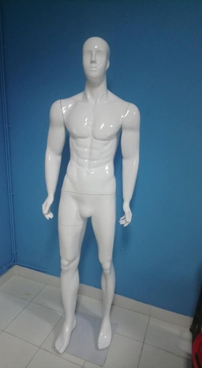 Manequim masculino branco de corpo inteiro em pé contra parede azul
