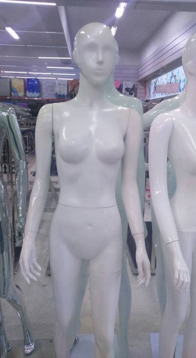 Mannequim feminino branco em plástico brilhante numa loja com outros manequins