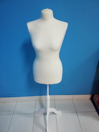 Mannequim feminino branco com suporte branco, parede azul e chão branco