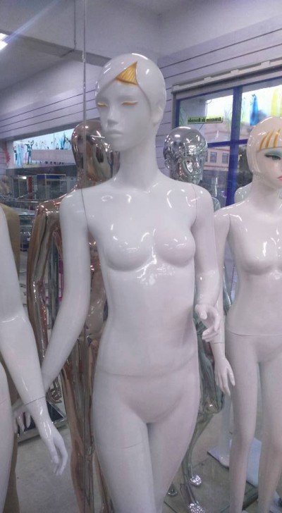 Mannequins femininos brilhantes de cores branca, dourada e cromada em loja