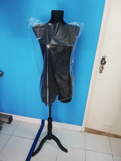 Manequim feminino preto coberto com plástico transparente em ambiente interior