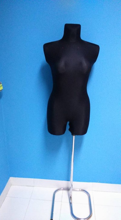 Manequim feminino preto com suporte metálico num fundo azul