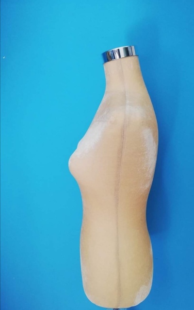 Manequim de costura feminino bege sobre fundo azul