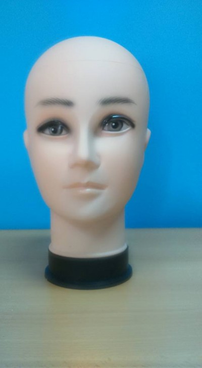 Cabeça de manequim em plástico com olhos pintados e sobrancelhas escuras