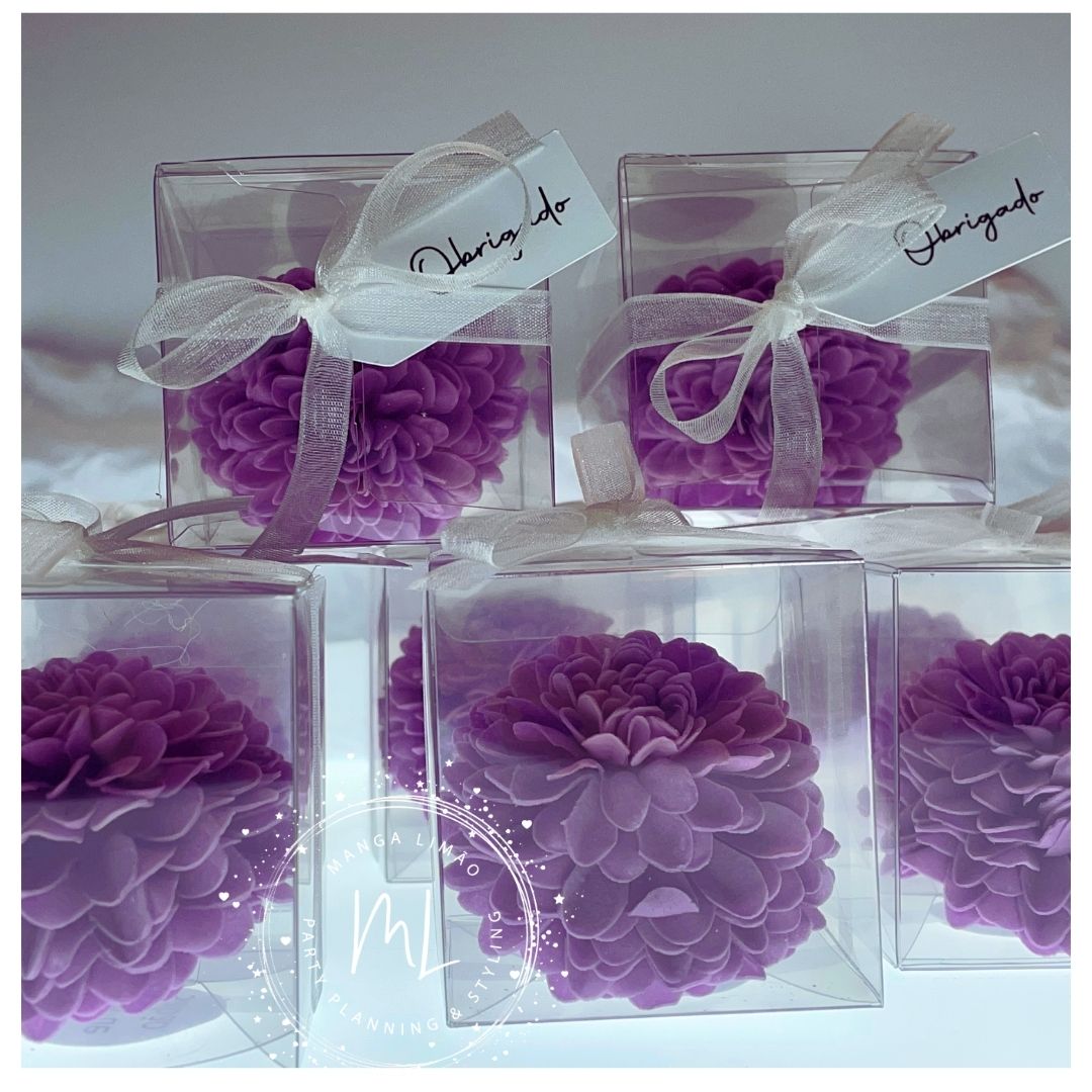 Cinco velas florais cor-de-rosa em caixas transparentes com fitas e etiquetas