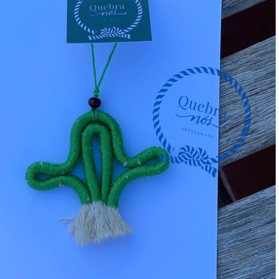 Adorno artesanal formato cacto em fio verde com franjas e cartão que diz Quebra nóz ARTESANATO