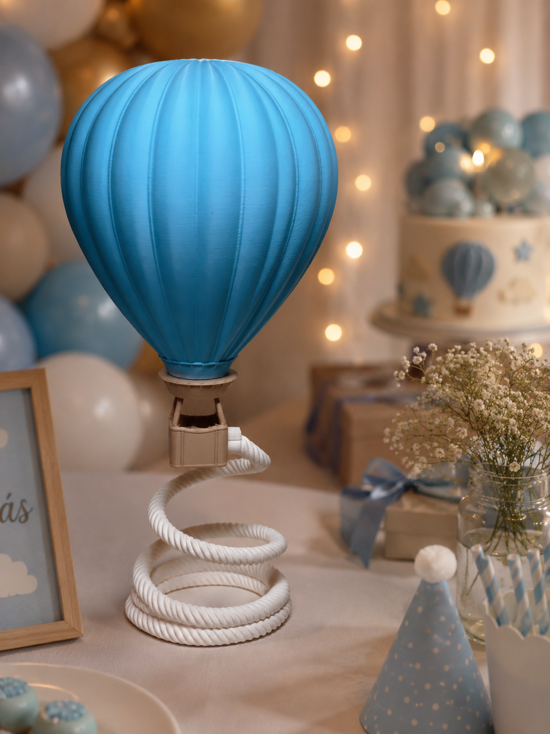 Decoração de balão de ar quente azul com base espiral branca numa mesa de festa