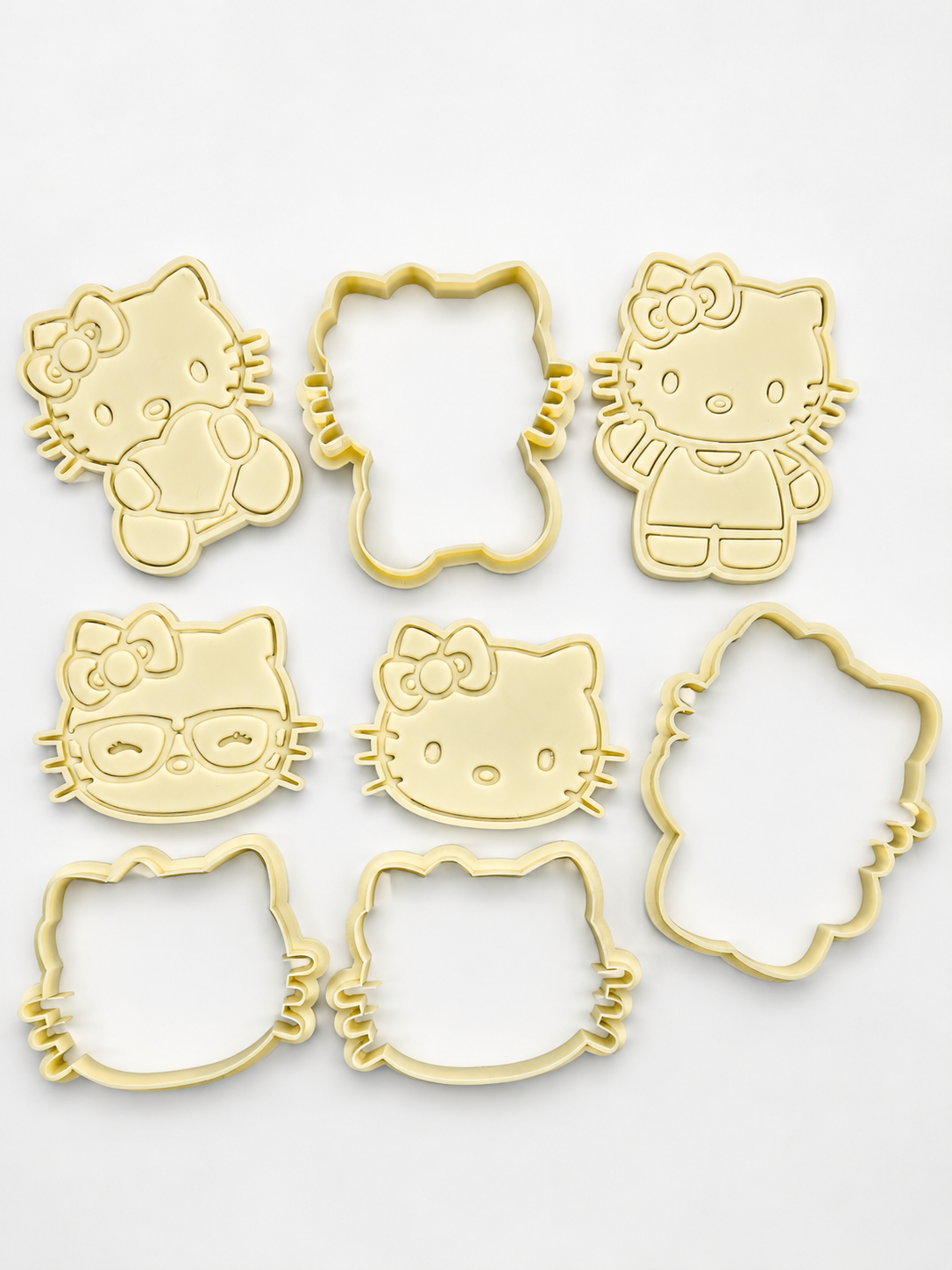 Cortadores de biscoitos amarelos da Hello Kitty com vários designs sobre fundo branco