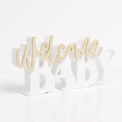 Decoração com as palavras Welcome Baby em letras douradas e brancas.