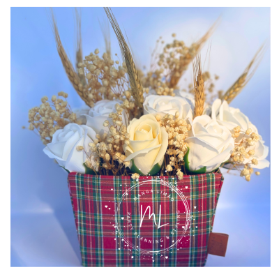 Arranjo floral com rosas artificiais e caixa de tecido xadrez