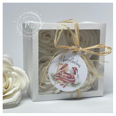 Caixa com flores decorativas brancas e etiqueta natalícia