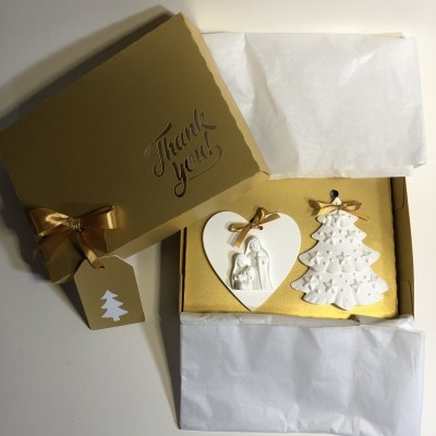 Caixa dourada com enfeites de Natal em cerâmica branca