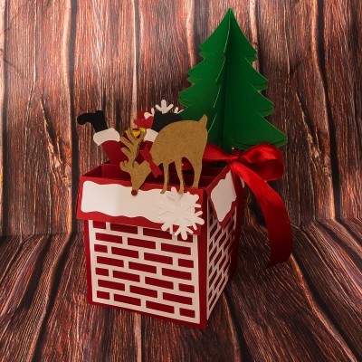 Caixa decorativa de chaminé vermelha e branca com figuras natalinas e laço vermelho