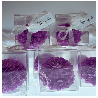 Cinco velas florais cor-de-rosa em caixas transparentes com fitas e etiquetas